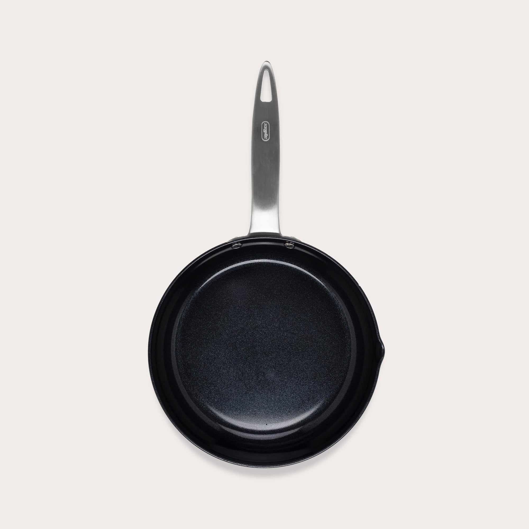 A black nonstick frying pan with a silver handle, viewed from above, against a plain light background.