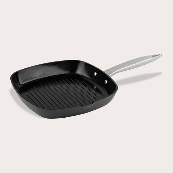 The Zyliss Ultimate Pro Ceramic Square Grill Pan is black with ridges, a silver handle, and a durable non-stick coating—ideal for indoor grilling. Displayed against a plain light background. 