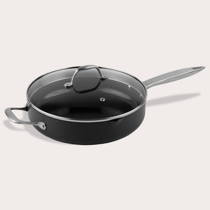 A Zyliss Ultimate Pro Ceramic Saute Pan With Lid, featuring a black nonstick surface, glass lid, long metal handle, and short helper handle, is displayed against a plain light background. 