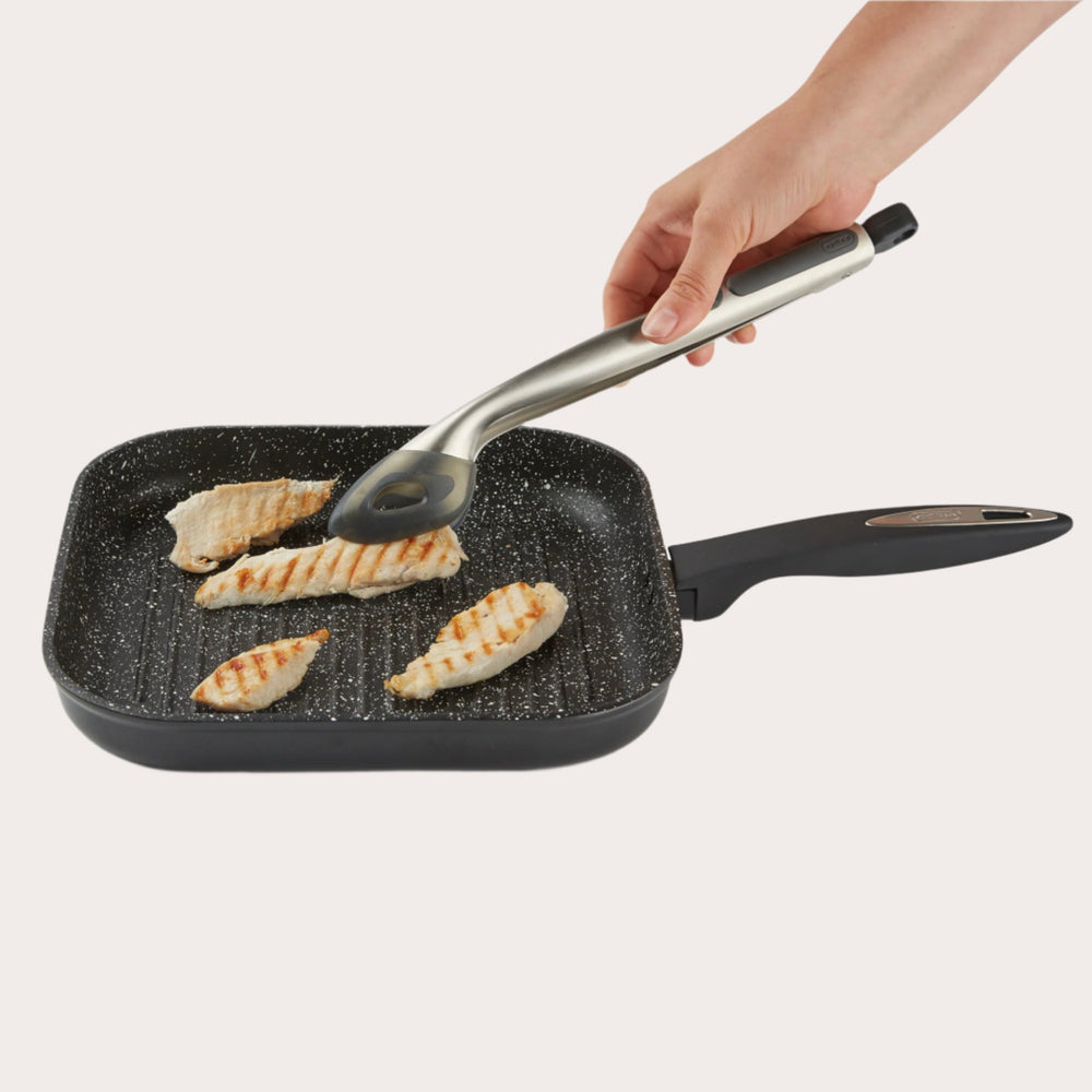 The Zyliss Silicone-Tipped Tongs feature a stainless steel body with black silicone tips and a curved handle, displayed against a plain, light background. Perfect for safe use with non-stick cookware. 