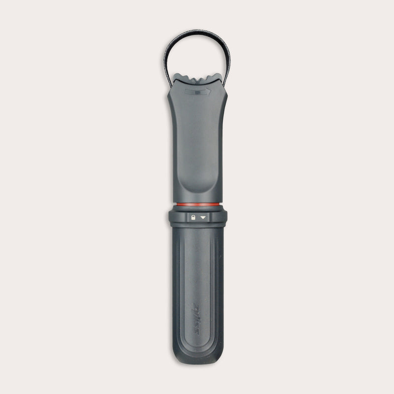 The Zyliss Jar Opener, shown vertically against a light background, is a black and gray handheld tool with a textured grip, integrated locking mechanism, circular top loop, and comes with a protective blade sheath.