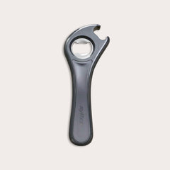 The Zyliss 5 In 1 Opener is a compact, metallic bottle opener with an ergonomic grip, wide handle, and circular opening for removing caps, shown on a plain light background.