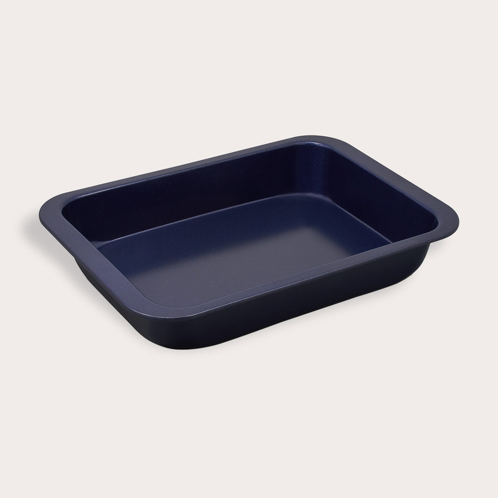 The Zyliss Durable Non-Stick Oven Tray is a rectangular, dark tray with rounded edges and sloped sides, designed for even heat distribution and easy food release. It’s displayed on a plain light background.