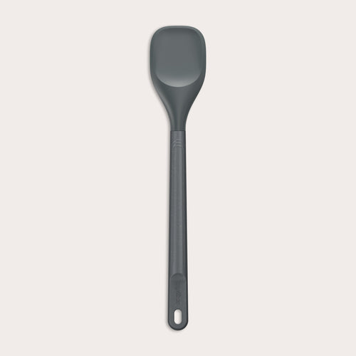 #medium The Zyliss Spoontula is dark gray, with a silicone head, long ergonomic handle, and a gently rounded rectangular bowl, pictured on a plain light background. #Medium