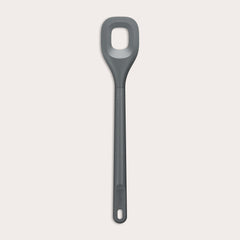 The Zyliss Square Mixing Spoon is a gray, heat-resistant silicone utensil with a long handle and a rectangular hole in the head. Shown on a plain light background, its dishwasher safe for easy cleaning. 