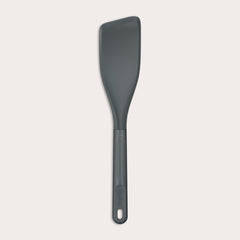 The Zyliss Easy Lift Turner is a gray, heat-resistant silicone utensil with a rectangular, angled head and long handle with hanging hole—perfect for non-stick cookware. Shown on a plain white background. 