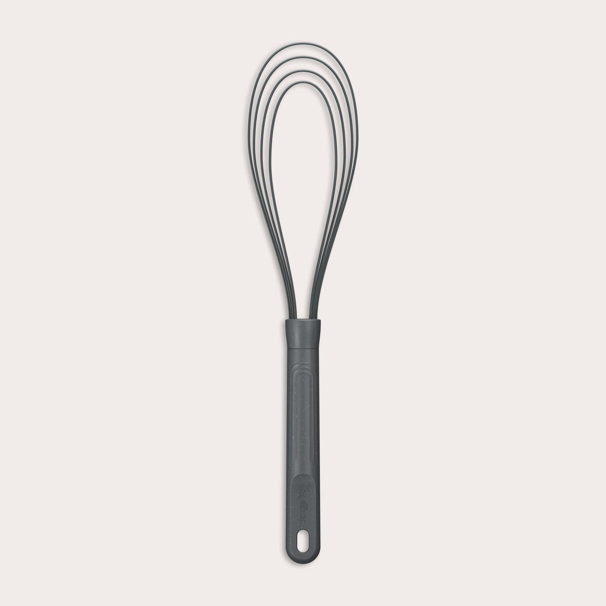 The Zyliss Flat Whisk Silicone features a black, heat-resistant silicone design with a long handle and looped wires, displayed on a plain light background. 