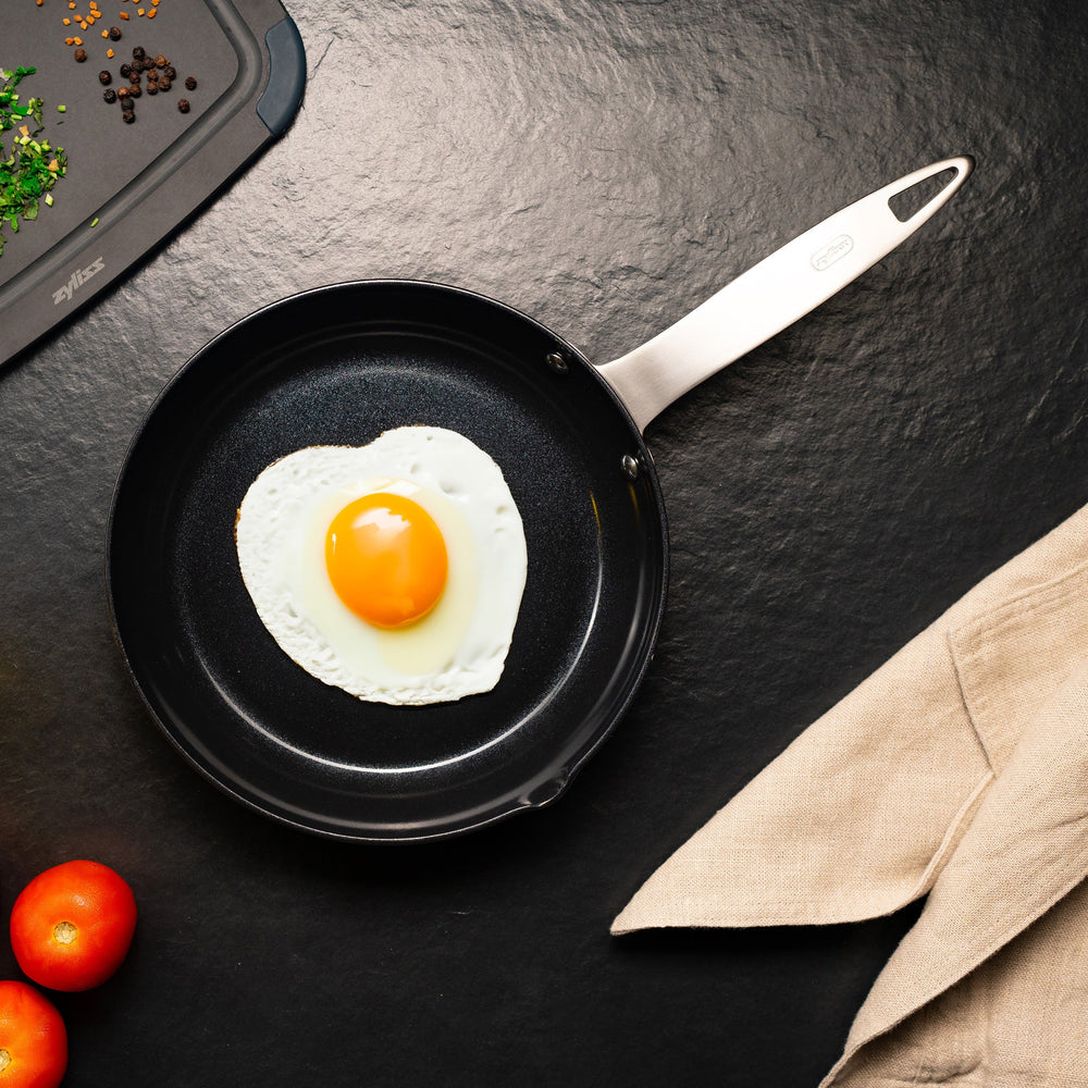 The Zyliss Ultimate Pro Ceramic Fry Pan, featuring a black non-stick coating and a silver metal handle, is displayed against a plain light background. #20cm/8"