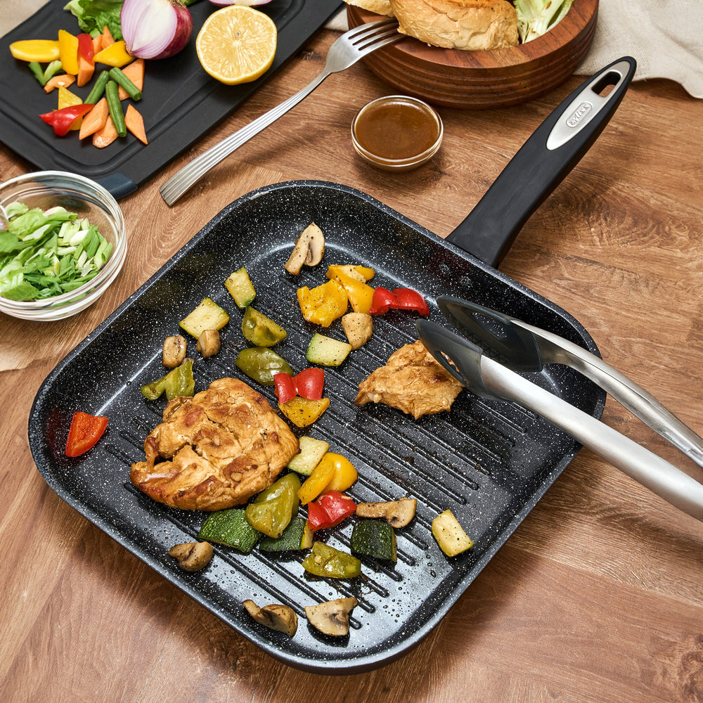 The Zyliss Ultimate Ceramic grill pan is black, square with ridges, a long handle, and a non-stick coating, shown on a plain light background.