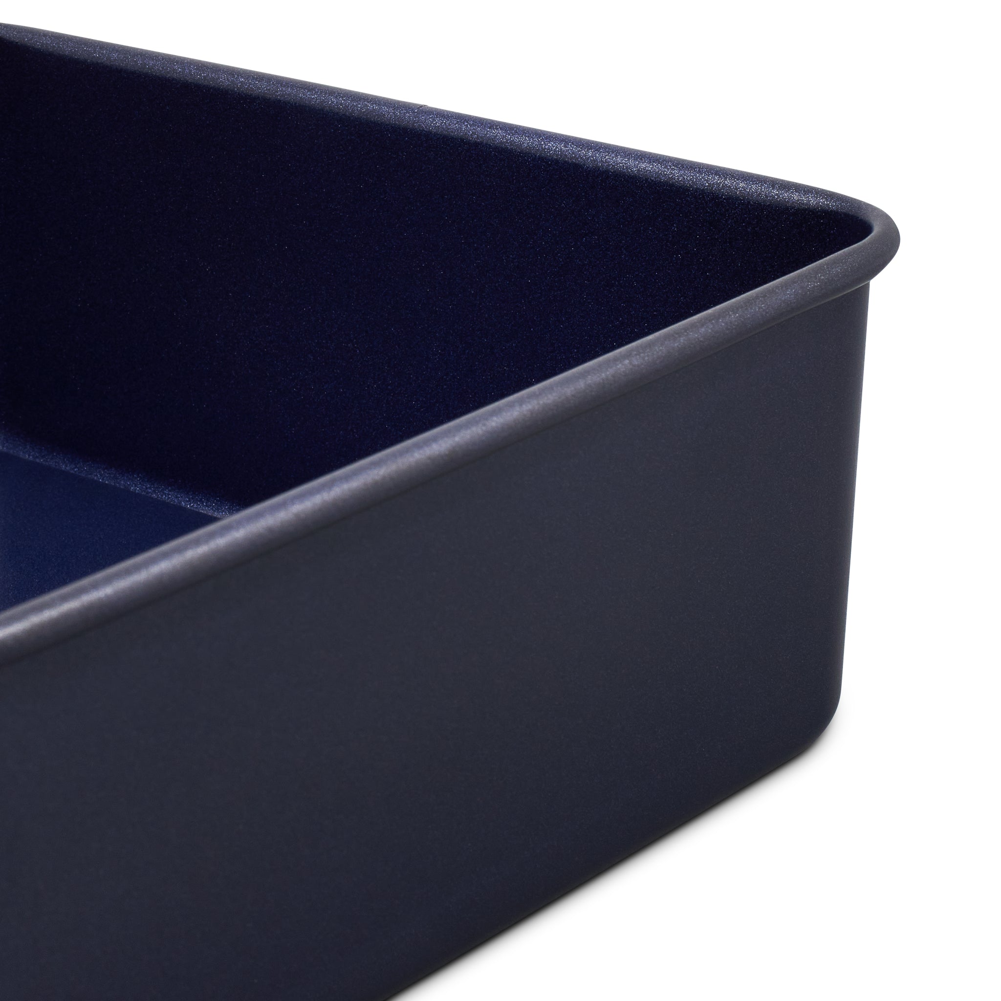 Close-up of a dark blue rectangular baking pan with rounded corners, shown against a white background.