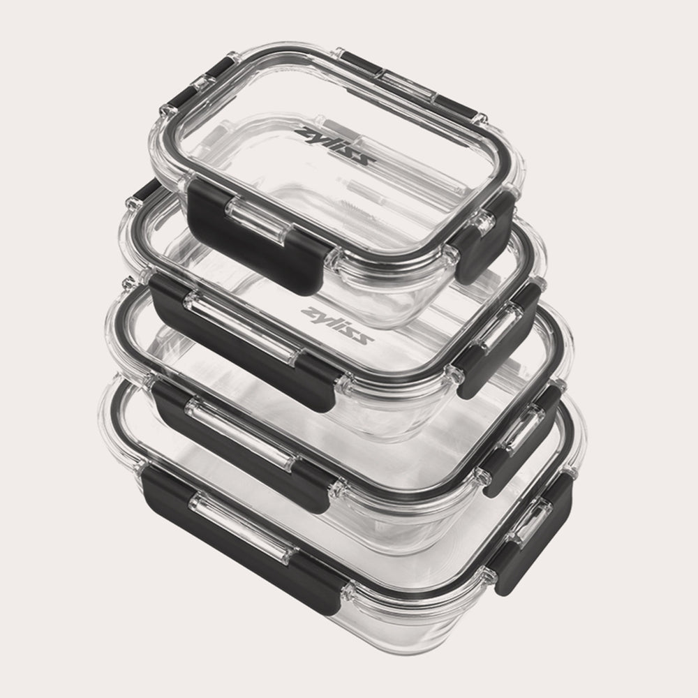 The Zyliss 4-Piece Glass Container Set features clear borosilicate containers with black locking lids, stacked neatly for leak-proof food storage against a plain white background. 