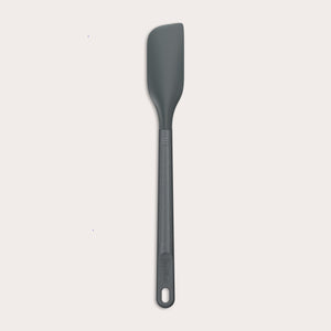 The Zyliss Spatula, featuring a long handle and flat, angled grey silicone head, is displayed against a plain white background.